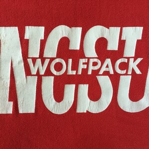 May include: White text on a red background reads "NC State Wolfpack".