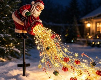 Op de afbeelding: Een kerstmanfiguur op een zwarte paal, gekleed in een rood pak met een witte baard, die een rode zak vasthoudt waaruit een waterval van warmwitte kerstverlichting, kleine sterretjes, miniatuurcadeautjes en zuurstokken naar buiten stroomt.