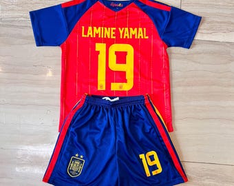 May include: A red and blue football kit comprising a jersey and shorts, featuring the name LAMINE YAMAL and the number 19 in yellow. The jersey has blue sleeves and a red body with thin vertical lines. The blue shorts display the number 19 and a team crest.