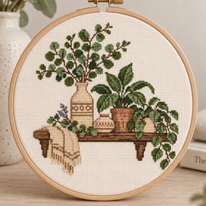 May include: A cross-stitch embroidery piece in a round wooden hoop featuring a shelf with three potted plants, a tall vase, and a draped beige cloth. The design uses various shades of green for the foliage and brown for the shelf and pots.