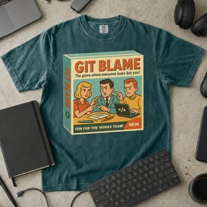 Puede incluir: Una camiseta de color verde azulado oscuro con el gráfico de una caja de juego titulada GIT BLAME. La ilustración muestra a tres personas señalándose entre sí alrededor de un portátil con símbolos de código. El texto dice: The game where everyone loses but you!