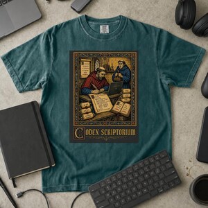 Może przedstawiać: Ciemnozielony t-shirt z nadrukiem graficznym przedstawiającym dwóch mnichów w skryptorium. Jeden mnich pisze na laptopie, podczas gdy drugi stoi obok. Wzór zawiera zwoje, książki oraz napis "CODEX SCRIPTORIUM" w ozdobnej ramce.