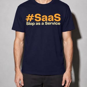 May include: A navy blue short-sleeve t-shirt featuring the text #SaaS in large orange letters on the chest, with the words Slop as a Service printed in smaller white letters directly underneath the hashtag.