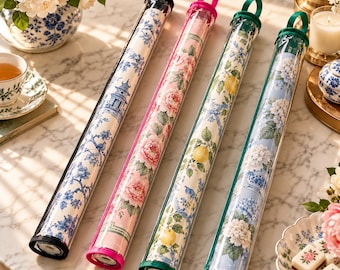 May include: Four cylindrical clear plastic storage tubes containing rolled fabric or paper sheets. Each tube features a colored top cap with a handle: black, pink, green, and dark green. The contents display floral, lemon, and pagoda patterns.
