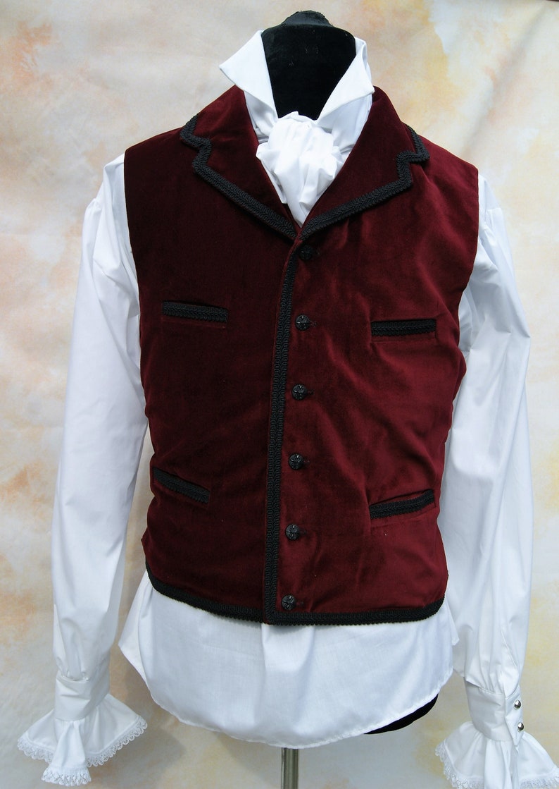 May include: A burgundy velvet vest with black trim and buttons. The vest has a shawl collar and two pockets.