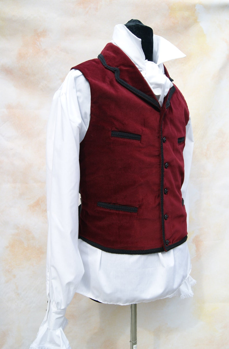 May include: A burgundy velvet vest with black trim and a white shirt underneath.