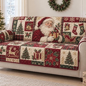 May include: A quilted sofa cover featuring a festive patchwork design with images of Santa Claus holding a gift, Christmas trees, poinsettias, bells, stockings, and reindeer in shades of red, green, cream, and gold on a light-colored sofa.