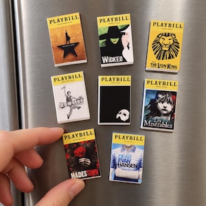 Pode incluir: Uma coleção de oito ímãs retangulares projetados para parecer programas de teatro Playbill em miniatura para musicais da Broadway, incluindo Hamilton, Wicked, The Lion King, Newsies, The Phantom of the Opera, Les Misérables, Hadestown e Dear Evan Hansen.