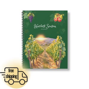 Op de afbeelding: Een spiraalgebonden dagboek met een donkergroene kaft met de tekst Harvest Season JOURNAL. De kaft toont een wijngaardlandschap bij zonsondergang, een tros paarse druiven en een verzameling appels en peren in de bovenste hoeken.