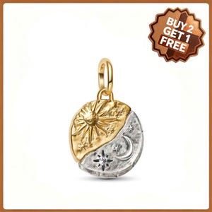 May include: A round pendant featuring a gold sun on one side and a silver moon with stars on the other. The pendant has a gold jump ring at the top. A brown badge in the corner displays the text BUY 2 GET 1 FREE in white capital letters.