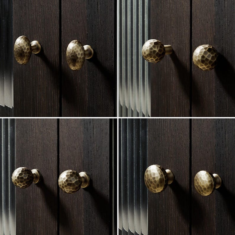 Op de afbeelding: Een collectie van acht ronde kastknoppen met een gehamerd, getextureerd oppervlak in een matte messing afwerking. Elke knop is gemonteerd op een donkerhouten paneel en toont een consistente ronde vorm en een metalen, gedeukt uiterlijk.