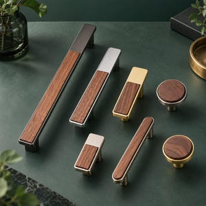 Puede incluir: Una colección de herrajes para muebles que combina madera oscura y acabados metálicos. El conjunto incluye tiradores rectangulares largos, manijas rectangulares más cortas y pomos circulares, uniendo la veta de la madera con metal.