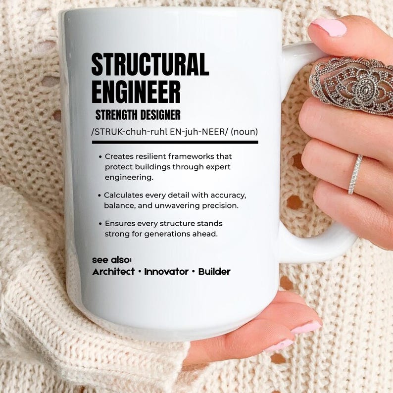 May include: A white ceramic mug featuring black text that defines a structural engineer as a strength designer. The text includes a phonetic pronunciation, a three-point description of engineering duties, and a see also section listing architect, innovator, and builder.