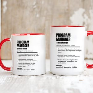 May include: Two white ceramic mugs with red interiors and handles. Each mug features black text defining a Program Manager as a strategy driver, including bullet points about overseeing projects, connecting teams, and mastering the big picture.