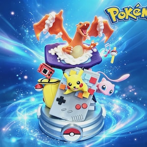 May include: A Pokémon display figure featuring Charizard emerging from a purple handheld console, Pikachu on a gray handheld console, and a pink Mew. The base is a silver Poké Ball design. The Pokémon logo is visible in the top right corner.