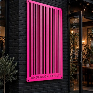 Puede incluir: Un letrero rectangular de metal rosa brillante con un patrón de código de barras vertical y el texto "ANDERSON FAMILY" impreso en negro en la parte inferior. El letrero está montado en una pared de ladrillo oscuro y texturizado junto a una puerta de cristal.