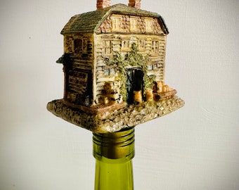 Great Christmas Village house made into a bottle stopper. Great stopper for a log cabin lover