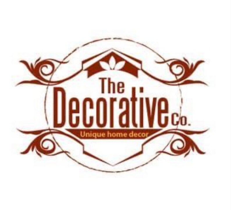 May include: A brown logo with a house icon and the text 'The Decorative Co.' in a circle with the words 'Unique home decor' below. The logo is surrounded by two decorative swirls.