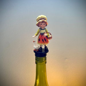 大きなボンネット ボトル ストッパー。1970 年代の素晴らしいフィギュアが、お気に入りのスピリッツの装飾品に変身します。