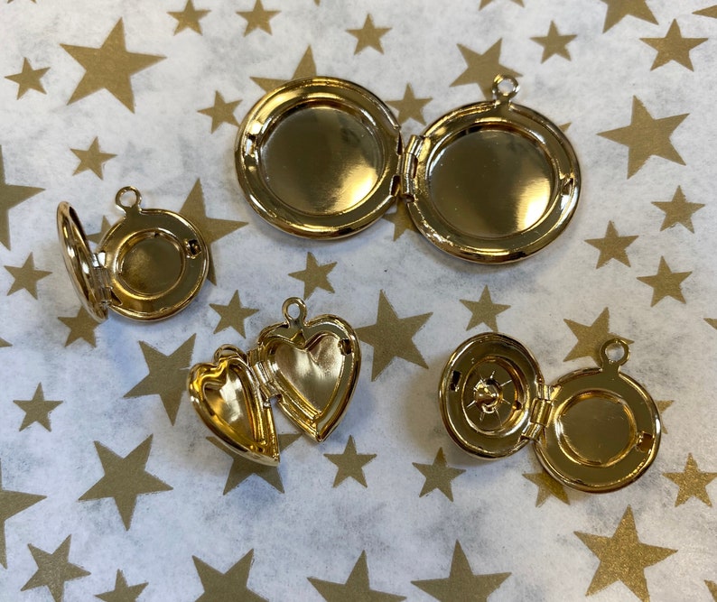 May include: Four gold-toned locket necklaces with different designs. The lockets are open to reveal the inside.