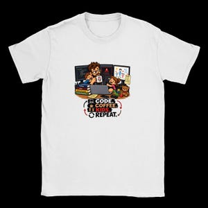 Może przedstawiać: Biały t-shirt z rysunkową ilustracją osoby pracującej przy biurku z dwójką dzieci, laptopem i monitorami komputerowymi. Tekst głosi: CODE. COFFEE. KIDS. REPEAT. Grafika zawiera książki, pluszowego misia oraz kubek z kawą.
