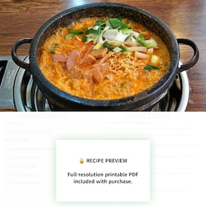 Op de afbeelding: Een zwarte stenen pot gevuld met borrelende oranje stoofpot met ramennoedels, gesneden lunchvlees en gehakte lente-uitjes. Een wit rechthoekig kader toont de tekst: RECIPE PREVIEW Full-resolution printable PDF included with purchase.