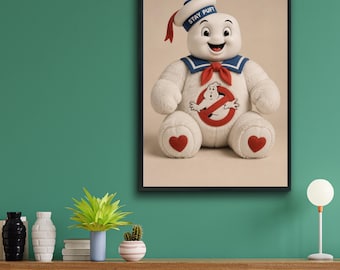 Może przedstawiać: Oprawiony wydruk ścienny przedstawiający pluszową postać Stay Puft Marshmallow Man. Biała figurka ma na sobie niebieski kołnierz marynarski z czerwoną chustą, pasującą czapkę z napisem STAY PUFT oraz czerwone naszywki w kształcie serc na stopach.