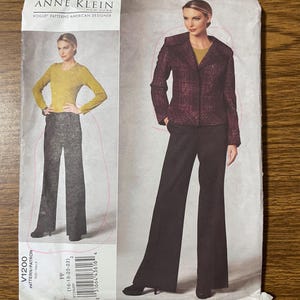May include: An Anne Klein Vogue Patterns sewing pattern envelope labeled V1200. The front displays a garment set featuring a long-sleeved mustard yellow top, dark wide-leg trousers, and a structured, dark purple plaid blazer with a wide collar.