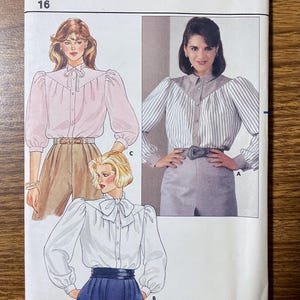 May include: Butterick sewing pattern 6467 for size 16 blouses. The envelope features illustrations and a photograph of three blouse variations with long sleeves, button-front closures, and distinct collar styles, including a pussy-bow and pointed collar.