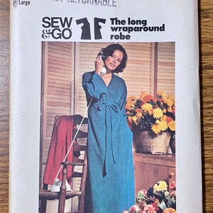 May include: A Butterick 3966 sewing pattern envelope for a long wraparound robe in size Large. The cover features a photograph of a teal long-sleeved robe with a tie waist, labeled Sew & Go, with text including Butterick, 3966, and The long wraparound robe.