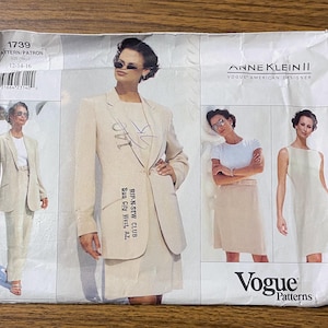 May include: A white paper sewing pattern envelope for Anne Klein II Vogue American Designer pattern 1739, size 12-14-16. The front displays illustrations of a beige blazer, skirt, and sleeveless dress, with handwritten text reading 140 and Rip-N-Sew Club.