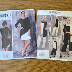 May include: Two Vogue Patterns sewing pattern envelopes by Tom and Linda Platt. The left envelope, V1470, shows a dark tunic over a white skirt. The right envelope displays various views of a color-blocked tunic and trousers in black and white.