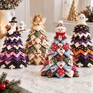 Puede incluir: Cuatro árboles decorativos de tela con parches triangulares acolchados en capas. El primero tiene un fantasma bruja con escoba, el segundo un ángel, el tercero un muñeco de nieve y el cuarto un fantasma en la punta, con distintos patrones estacionales.