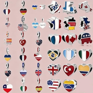 Könnte beinhalten: Eine Sammlung von Metallanhängern mit verschiedenen Nationalflaggen und länderspezifischen Motiven. Die Anhänger umfassen herzförmige Schmuckstücke mit emaillierten Flaggenmustern sowie geformte Anhänger, die bestimmte Länder repräsentieren.