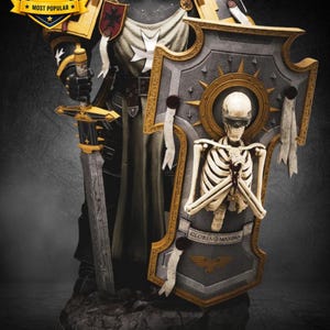 Könnte beinhalten: Eine detaillierte Figur eines Ritters in schwarz-goldener Rüstung, der ein langes Schwert hält. Der Ritter trägt einen großen Schild mit einer Skelettfigur mit Augenbinde und der lateinischen Inschrift GLORIA MAXIMA.