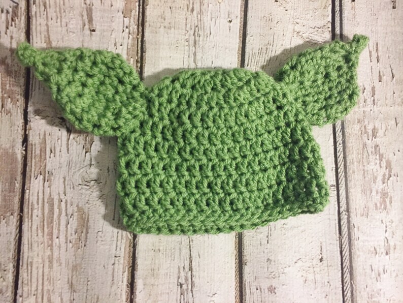Puede incluir: Sombrero de ganchillo verde con dos orejas grandes, que se asemeja a un personaje ficticio popular.