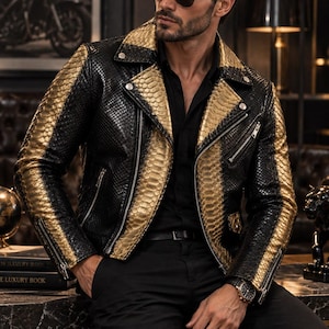 Peut inclure: Une veste de motard présentant un motif texturé en peau de serpent avec des panneaux alternés noirs et dorés métallisés. La veste comprend un revers cranté, des fermetures éclair en métal argenté sur le devant et les poignets, et des boutons-pression argentés.