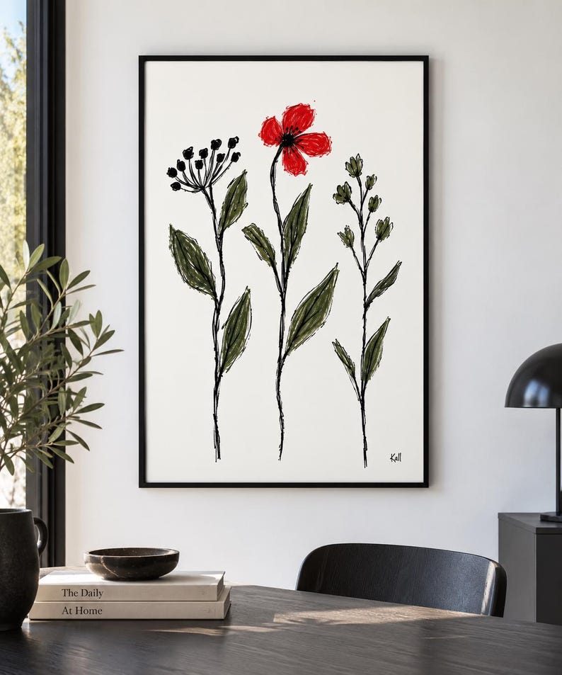 May include: A framed wall art print featuring a sketch-style illustration of three wildflowers on a white background. The central flower is bright red, while the two flanking plants are rendered in dark green and black ink lines. The artist signature Kall is visible in the bottom right corner.