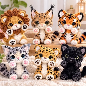 May include: A collection of six crocheted stuffed animals featuring a lion, a lynx, a tiger, a snow leopard, a leopard, and a black cat. Each creature has large dark eyes, raised paws with pink or dark pads, and a seated posture with a tail.