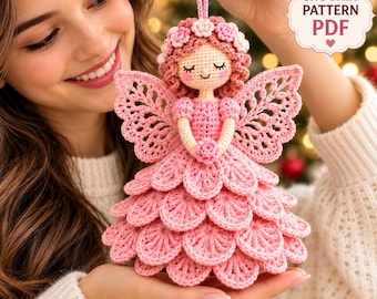May include: A crocheted angel ornament featuring a pink layered petal skirt, intricate lace-like wings, and a head adorned with small pink flowers. The doll has closed eyes and rosy cheeks. Text in the upper right corner reads CROCHET PATTERN PDF.