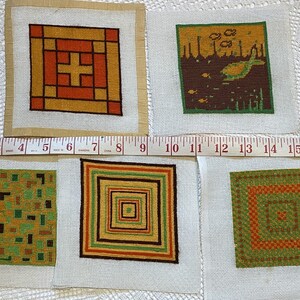 May include: Five needlepoint canvases with different geometric designs. The designs are in shades of green, orange, brown, and yellow. The canvases are all the same size and are mounted on a white background.