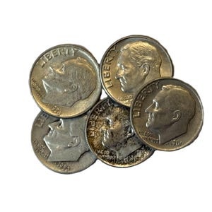 May include: A collection of silver dimes, each displaying a profile of a man and the word "LIBERTY". The coins are arranged in a slightly overlapping pattern, showcasing their details and dates.