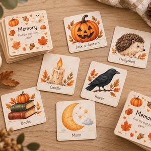 Peut inclure: Un jeu de mémoire composé de cartes carrées illustrées sur le thème de l'automne. Chaque carte porte une étiquette comme Jack-o'-lantern, Hedgehog, Candle, Raven, Books ou Moon. Les cartes sont décorées de citrouilles, feuilles et glands.