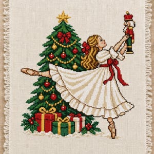Peut inclure: Une broderie au point de croix sur tissu beige à bords effilochés, représentant une danseuse blonde en robe blanche tenant un casse-noisette. Un sapin de Noël décoré de boules rouges et dorées, d'une étoile jaune et de cadeaux est en arrière-plan.