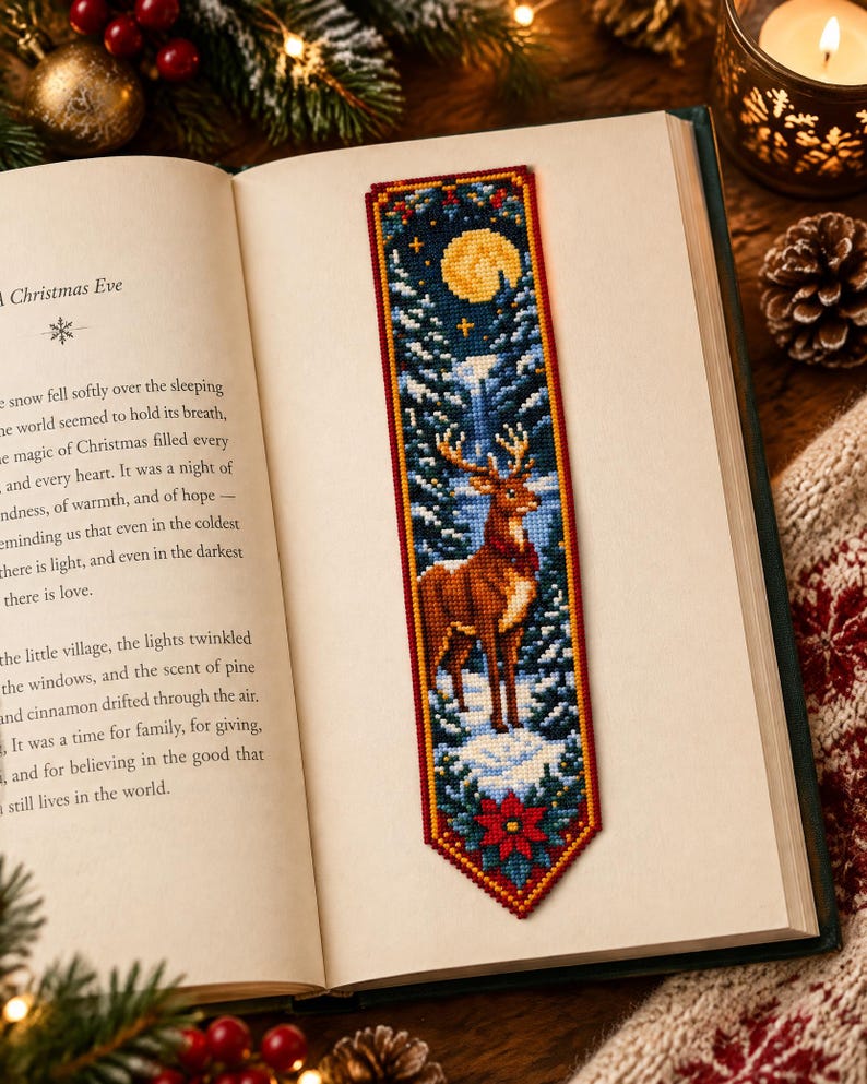 May include: A rectangular cross-stitch bookmark featuring a brown deer standing in a snowy forest at night. The design includes a yellow full moon, dark blue sky, evergreen trees, and a red poinsettia flower at the bottom, all bordered in red.