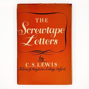 May include: A hardcover book titled The Screwtape Letters by C.S. Lewis, Fellow of Magdalen College, Oxford. The book cover is a solid orange color with white serif lettering for the title and author name, featuring a thin black border line.
