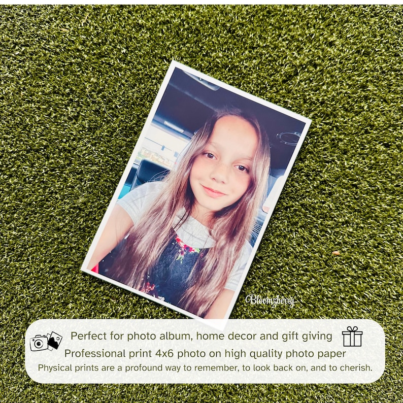 May include: A 4x6 inch photograph of a young girl with long brown hair, wearing a floral print dress, smiling at the camera. The photo is printed on high quality photo paper.