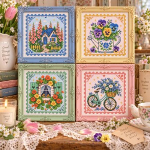 May include: Four square cross-stitch embroideries in ornate frames. Top left: a blue frame with a cottage. Top right: a yellow frame with pansies in a watering can. Bottom left: a green frame with a window and flowers. Bottom right: a pink frame with a bicycle.