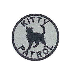 May include: A gray and black embroidered patch with a black cat silhouette and the text "Kitty Patrol" in a circle.