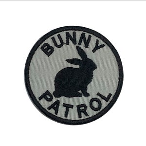 May include: A gray and black embroidered patch with the text "Bunny Patrol" and a black silhouette of a rabbit.